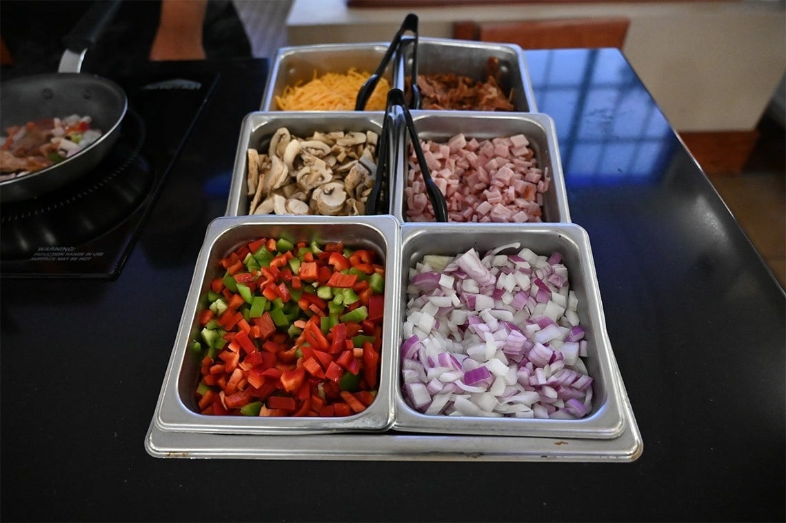 a tray of chopped vegetables including peppers onions and mushrooms