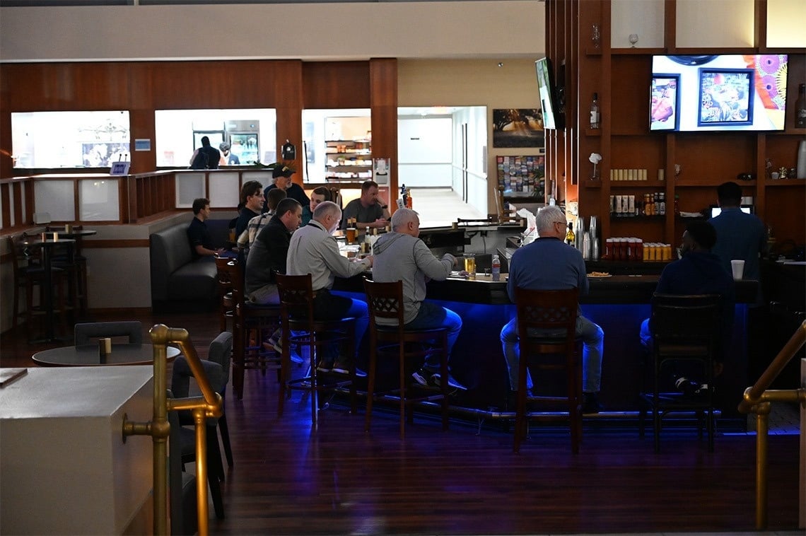 a group of men sit at a bar in a restaurant