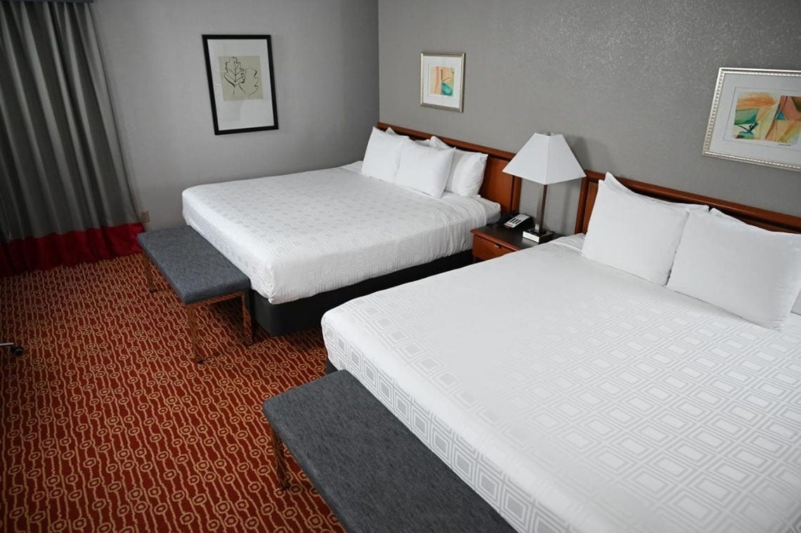 a hotel room with two beds and a bench