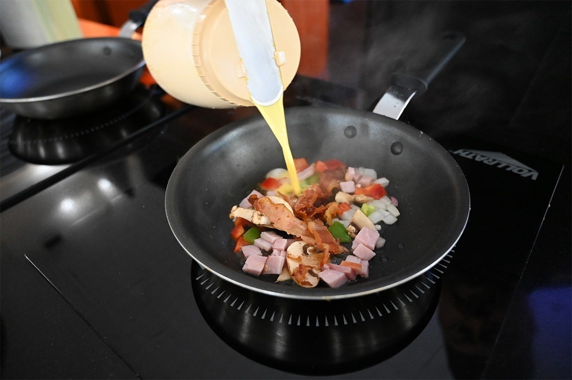 a person is pouring liquid into a pan that says vollrath on it