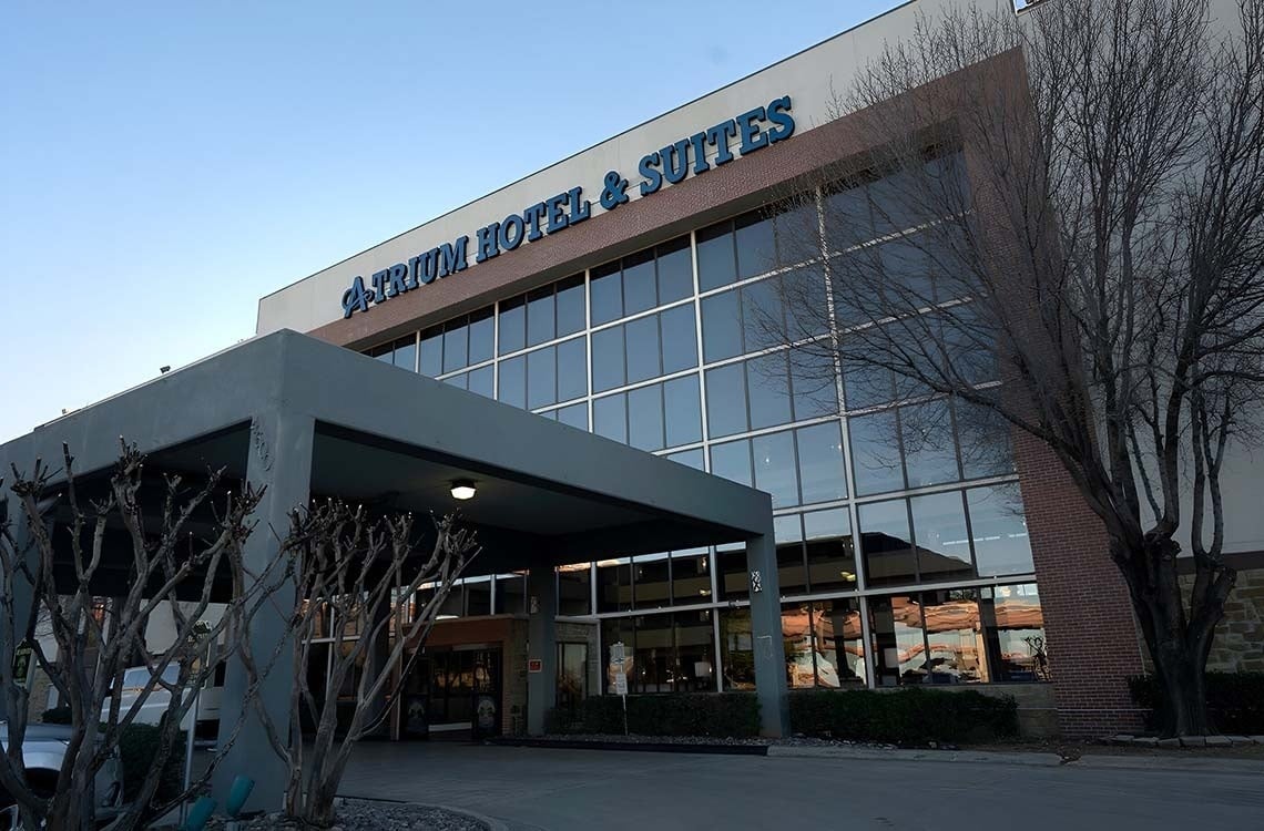 atrium hotel and suites is a large building with lots of windows