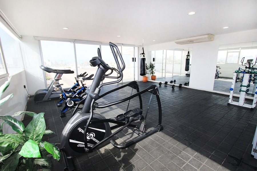 un gimnasio con muchos aparatos y una bicicleta elíptica