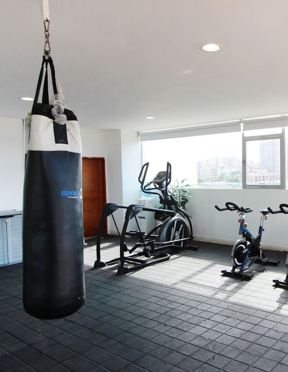 un gimnasio con un saco de boxeo y bicicletas de ejercicio
