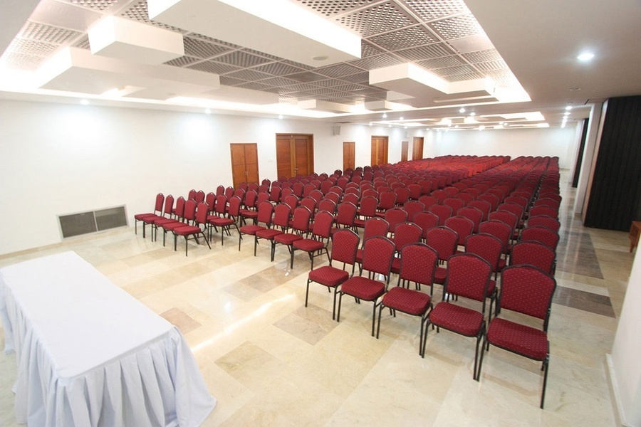 una sala de conferencias con mesas azules y sillas rojas