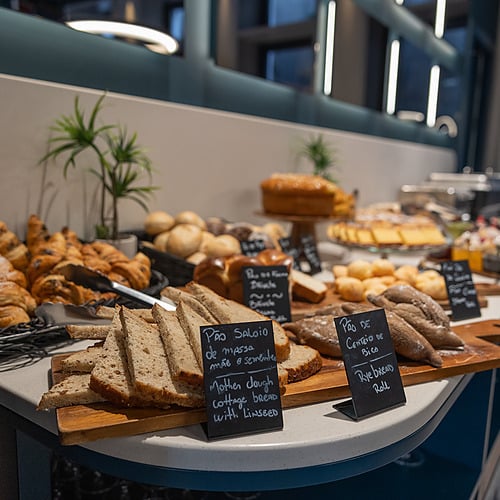 Buffet de café da manhã: Axis: Corporate com pães, croissants e doces.