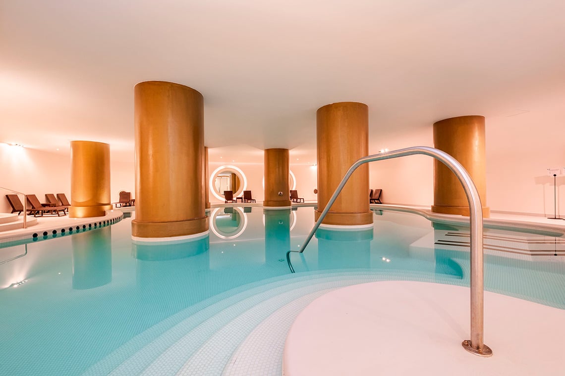 Piscina interior serena com colunas douradas e @Vermar | Axis Hotéis & Golfe | Website Oficial para relaxar.