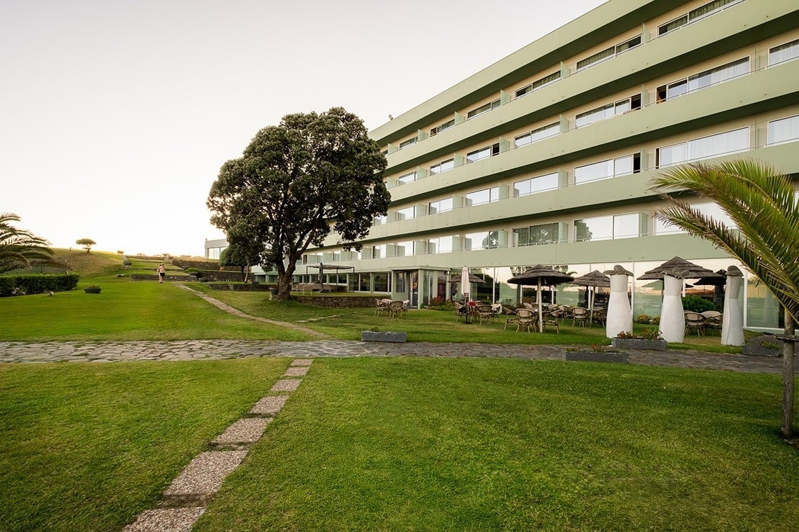 um grande prédio verde com muitas janelas