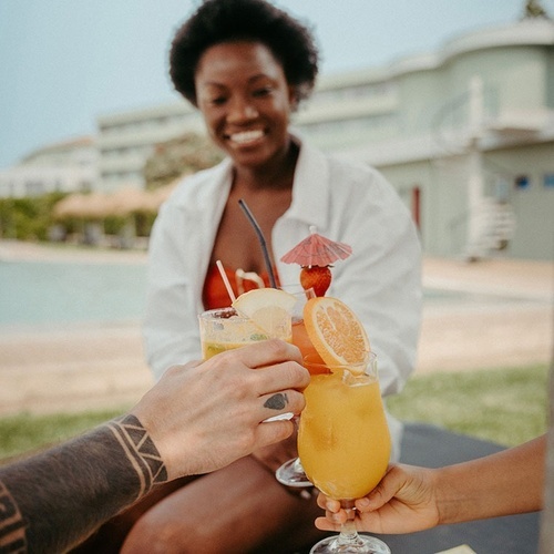 a group of people toasting with drinks and a plate of food