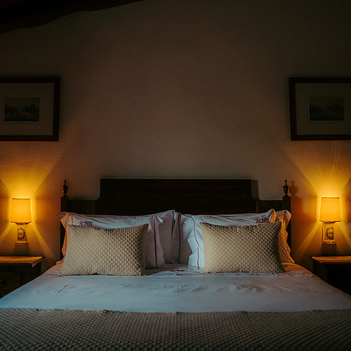 Cama confortable con mesitas de noche y lámparas en un hotel Axis: Corporate