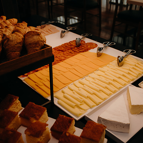 Desayuno buffet con cruasanes, fiambres, quesos y pasteles. Axis: Corporate
