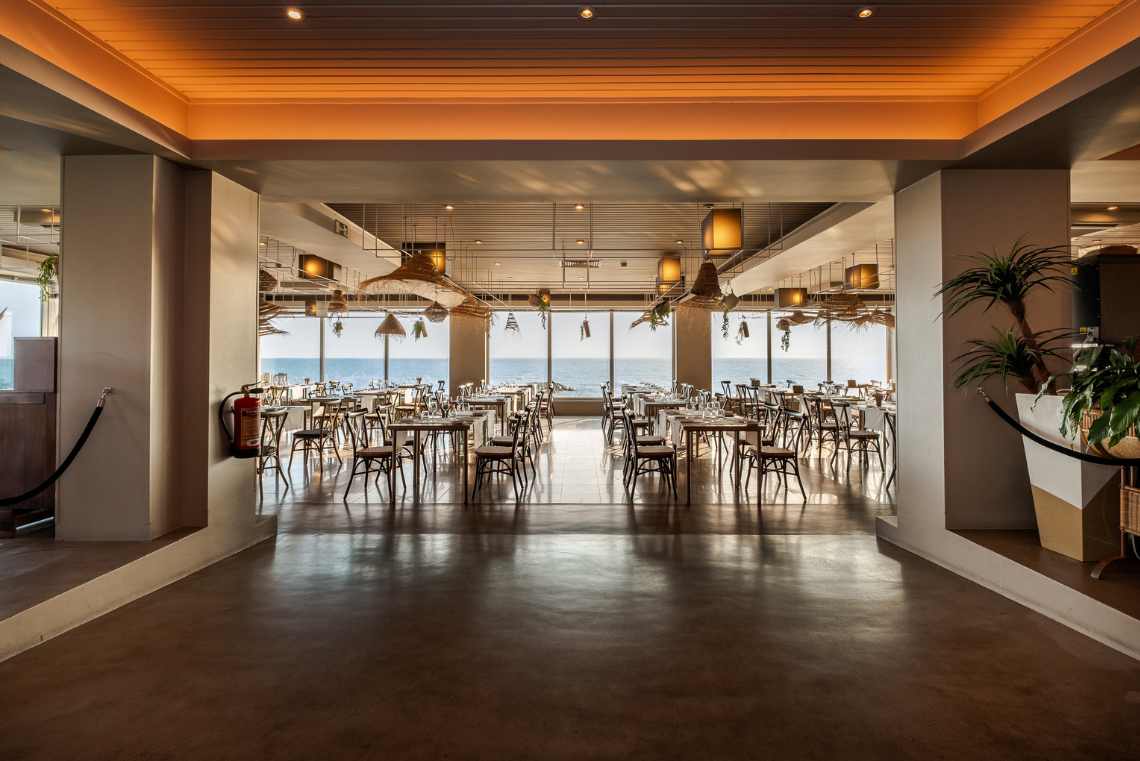 uma sala de jantar com mesas e cadeiras e um extintor de incêndio