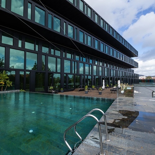 a large building with a swimming pool in front of it