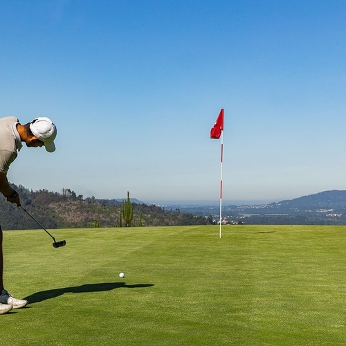 a man is swinging a golf club on a golf course