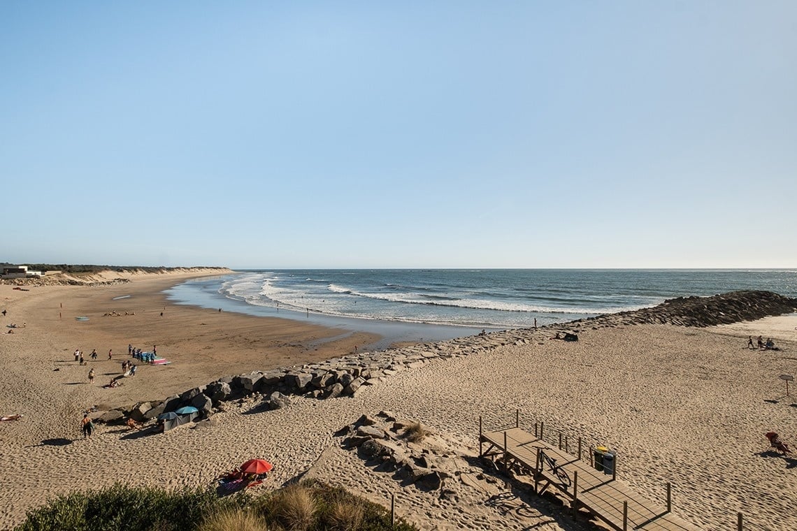 uma praia cheia de pessoas e ondas
