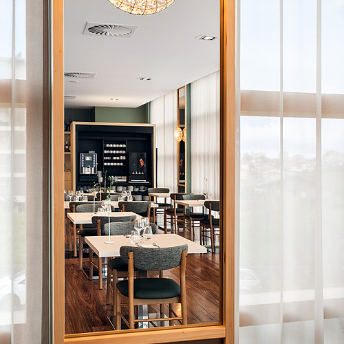 Restaurante elegante y moderno con mesas, sillas y decoración acogedora. Axis: Corporate