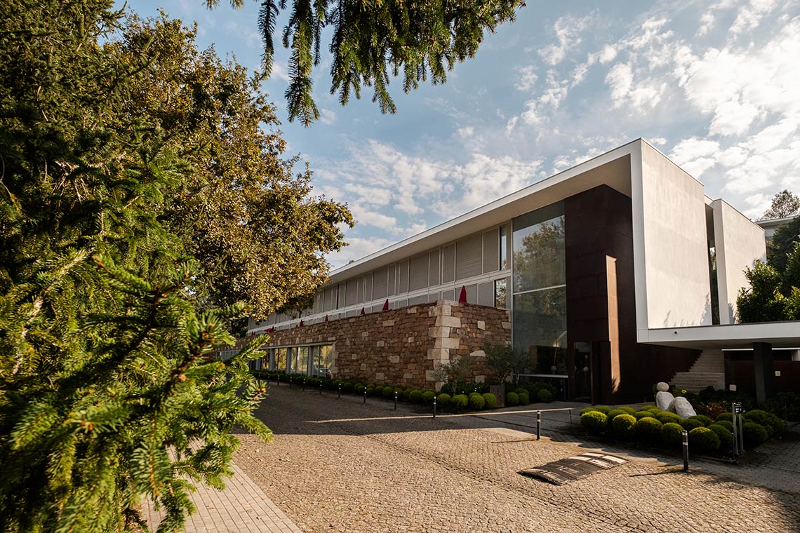 Architecture moderne du Ponte de Lima  | Axis Hotéis & Golfe | Site Officiel : façade en pierre, verre et métal avec jardin paysager.