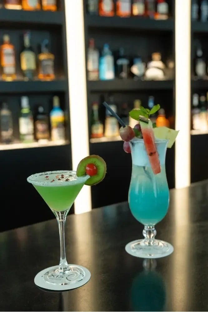 un martini vert et un cocktail bleu sont assis sur une table