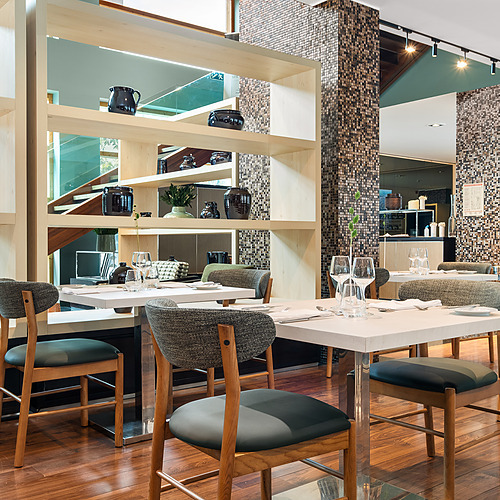 Mesas elegantes y sillas tapizadas en restaurante de hotel, listas para Axis: Corporate