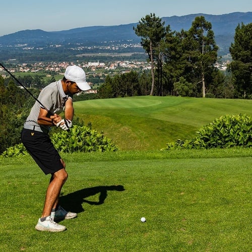 a man is swinging a golf club on a golf course