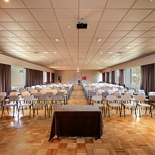 Axis: Corporate: Sala de conferencias vacía con sillas y proyector.