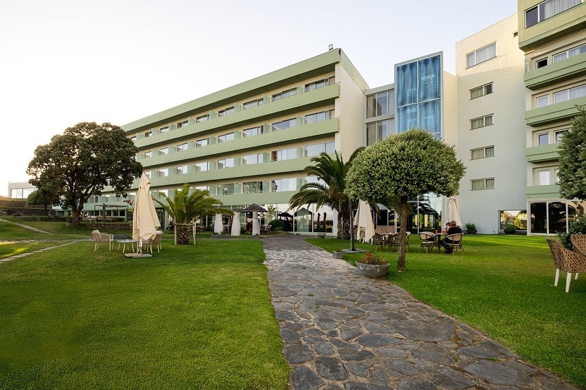 um caminho de pedra leva a um grande prédio com muitas janelas