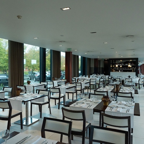 a restaurant with many tables and chairs and a large exit sign