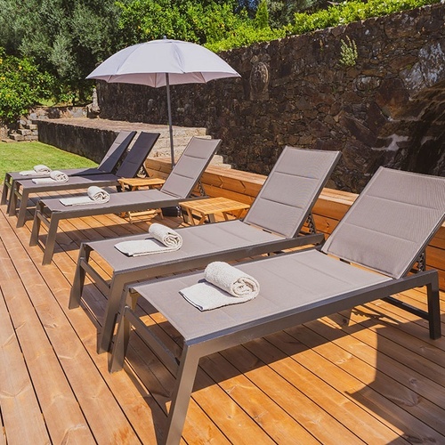 a wooden deck with lounge chairs and an umbrella