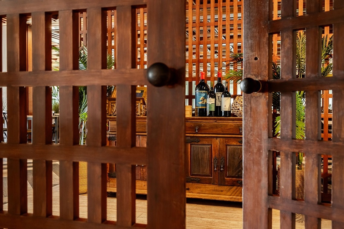 a few bottles of wine are behind a wooden fence