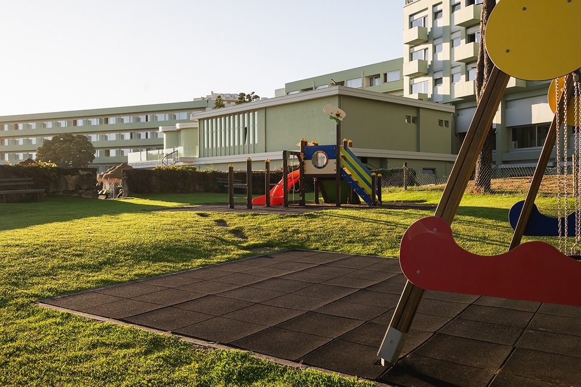 um parque infantil com um balanço vermelho e amarelo