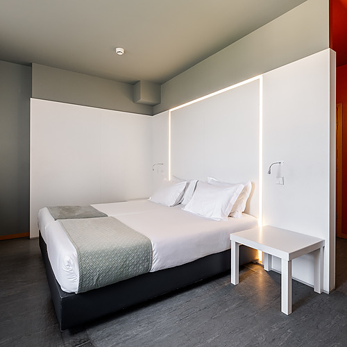 Dormitorio moderno con cama doble, escritorio y luz ambiental. Ideal para Axis: Corporate.