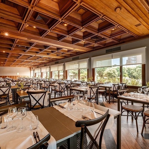 a restaurant with a wooden ceiling and lots of tables and chairs