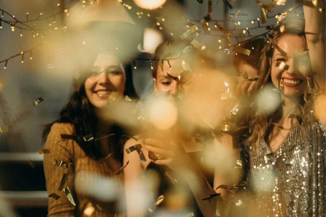 a glass of red liquid with a straw on the beach