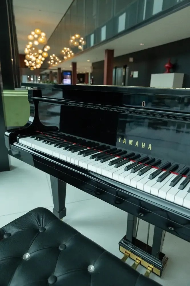 um piano de cauda preto com a palavra yamaha ao lado