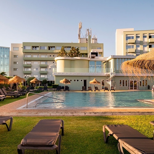 a large swimming pool surrounded by chairs and umbrellas