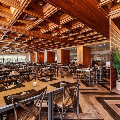 tables and chairs in a restaurant with a wooden ceiling