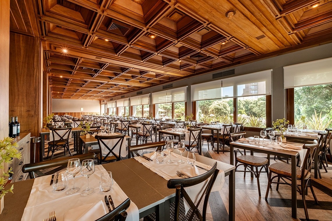 a restaurant with a wooden ceiling and lots of tables and chairs