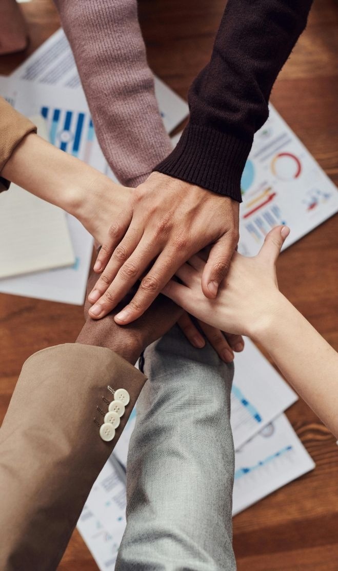 a group of people are putting their hands together