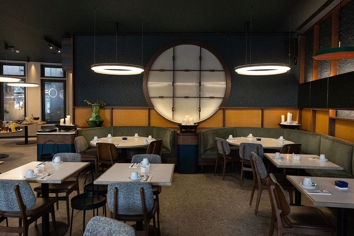 a restaurant with tables and chairs and a large oval window