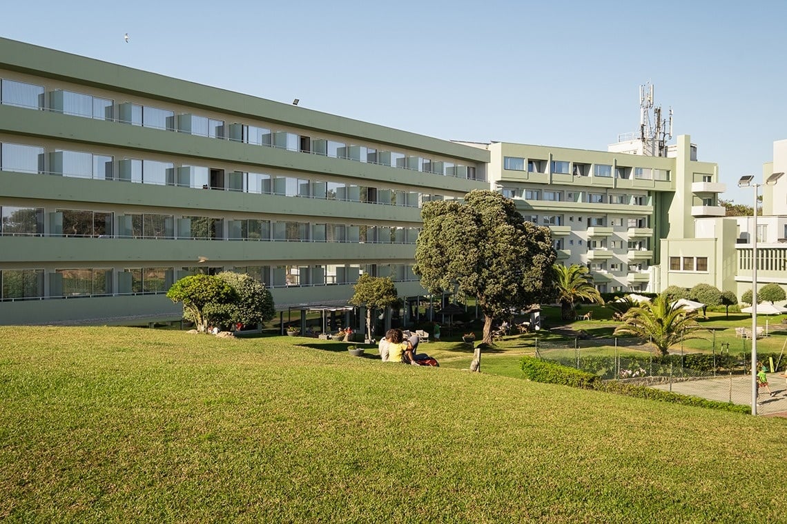 um grande prédio verde com muitas janelas