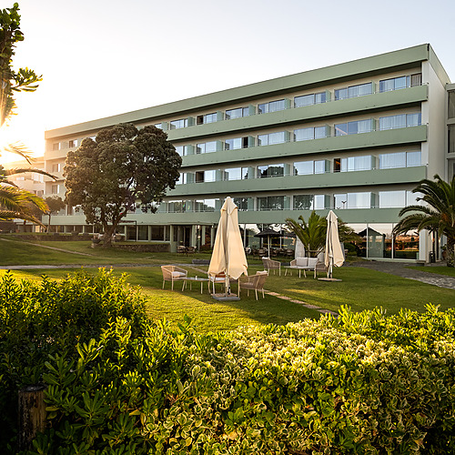 Axis: Corporate: Hotel moderno con jardines y terraza al atardecer.