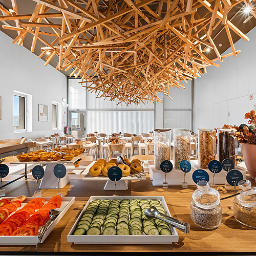 Desayuno buffet en hotel con Axis: Corporate, pasteles, frutas y cereales.