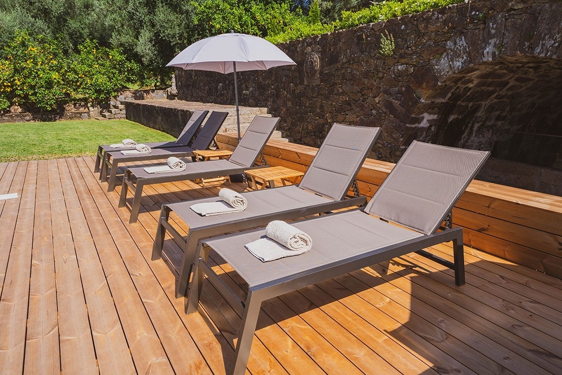 um deck de madeira com cadeiras e guarda-chuvas