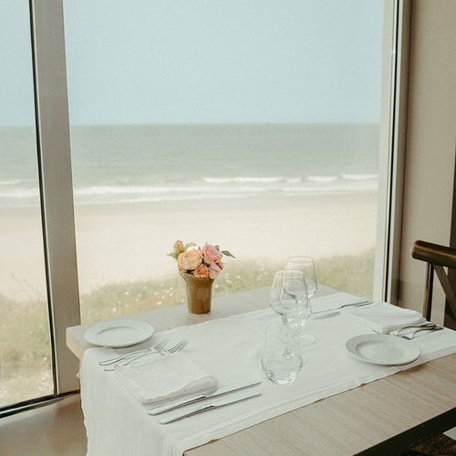 a table set for a meal with a view of the ocean