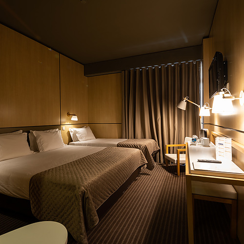 Quarto de hotel com duas camas,Axis: Corporate, secretária e luzes.