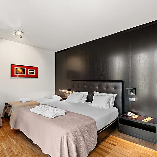 Quarto de hotel moderno com duas camas, roupões e TV. Axis: Corporate