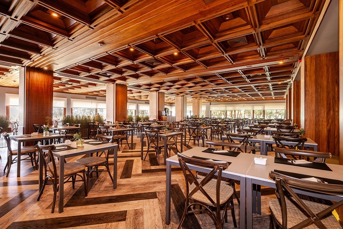 a restaurant with tables and chairs and a wooden ceiling