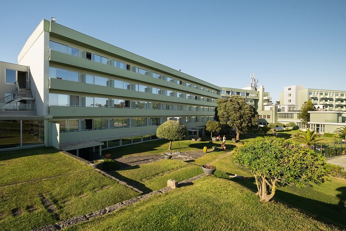 um grande prédio verde e branco com muitas janelas