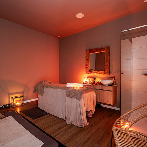 Relájate en nuestra Axis: Corporate de spa: mesa de masaje, velas, ducha y sillón.