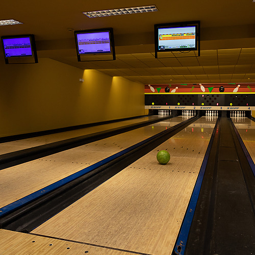 Pista de bolos interior con bola verde y pantallas, perfecta para una experiencia de ocio y diversión Axis: Corporate.