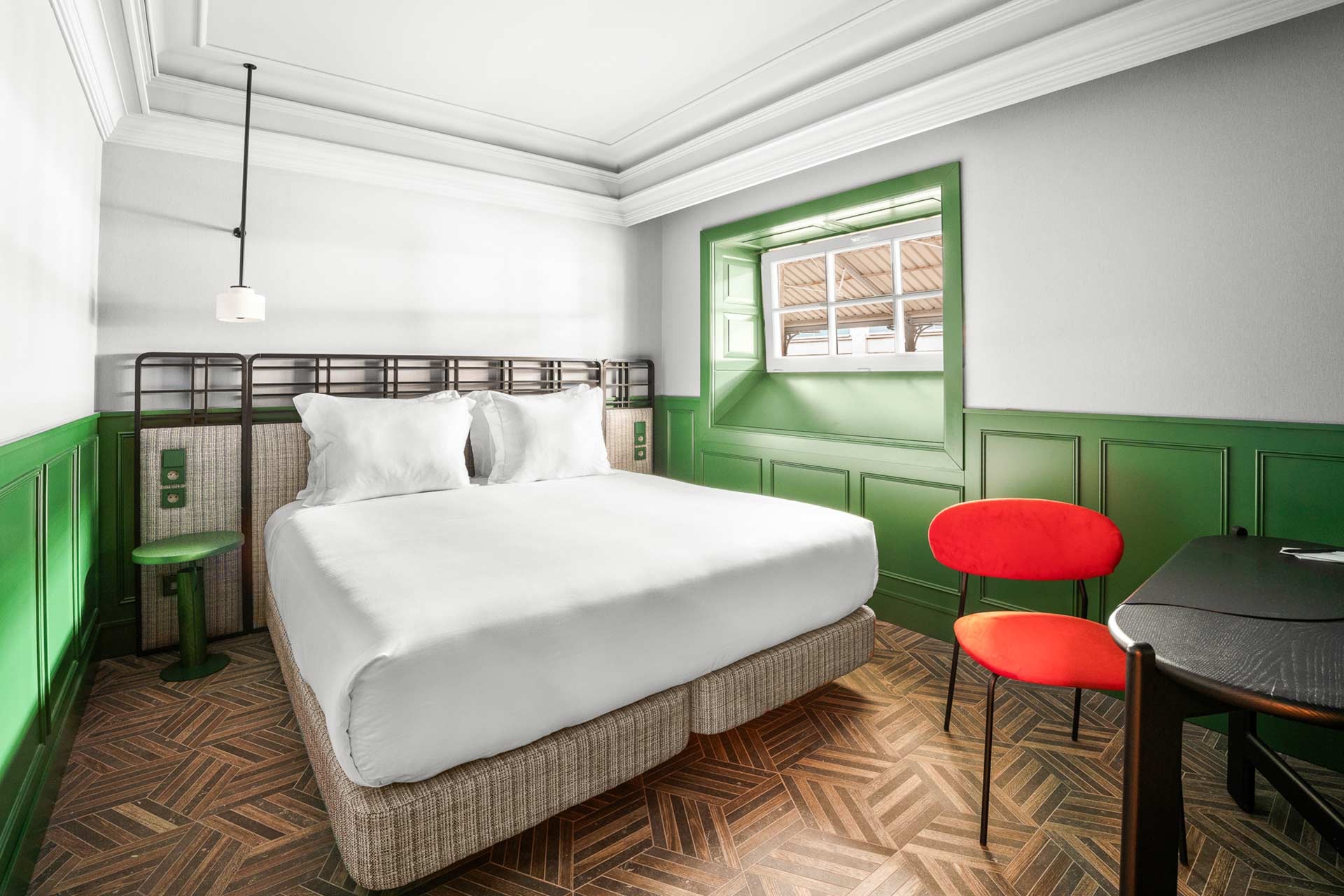Chambre moderne avec lit douillet, chaise rouge et parquet. Avenida | Axis Hotéis & Golfe | Site Officiel